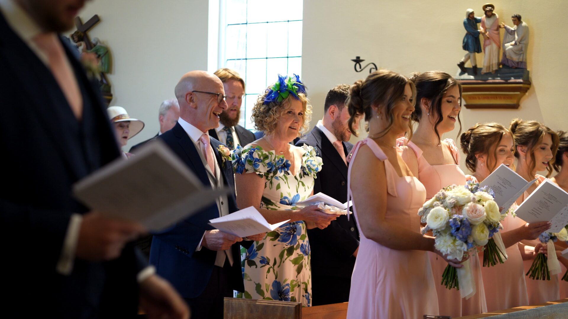 Guests giggle during the church hymns during a wedding ceremony in Harrogate