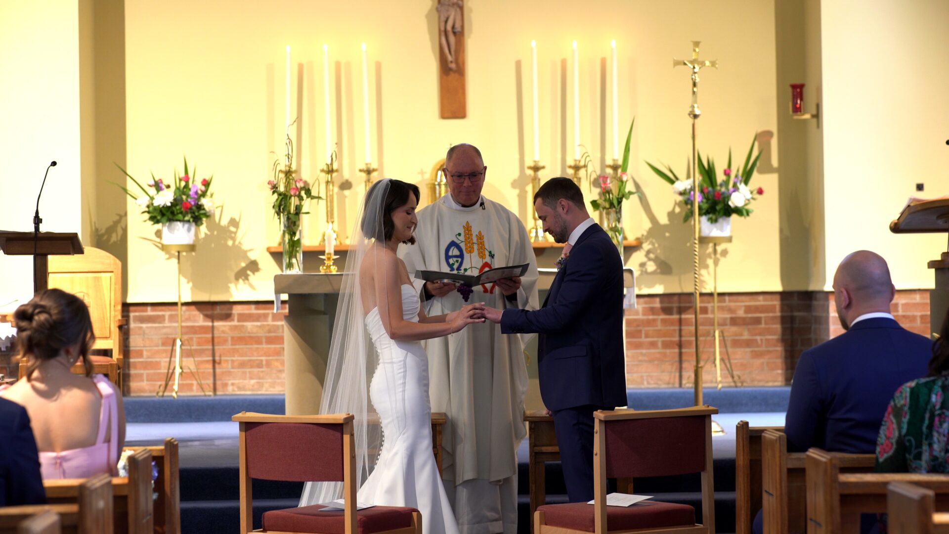 a documentary wedding videographer captures the couple exchange wedding rings at St. Aelred's Catholic Church Harrogate