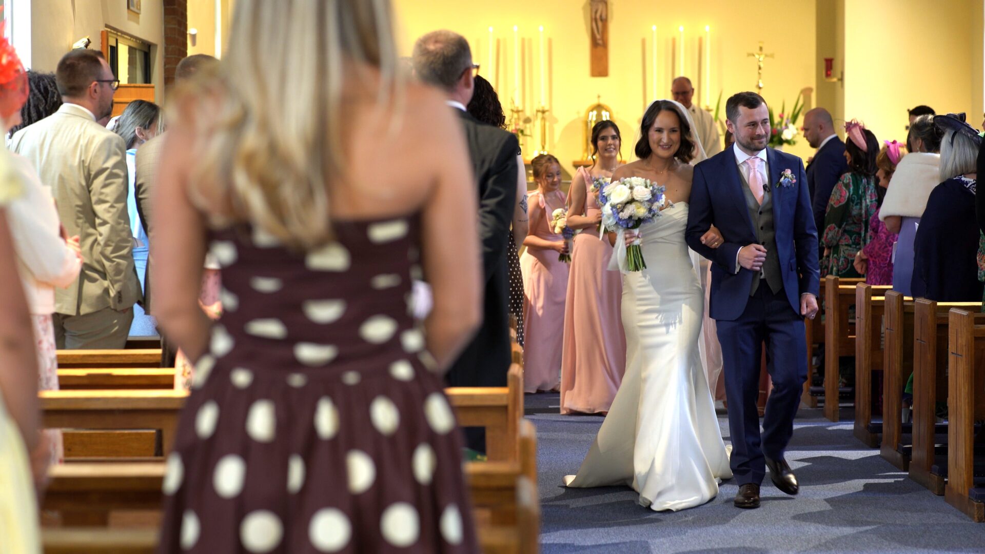 a bride and groom walk down the aisle smiling after their wedding ceremony at St. Aelred's Catholic Church Harrogate