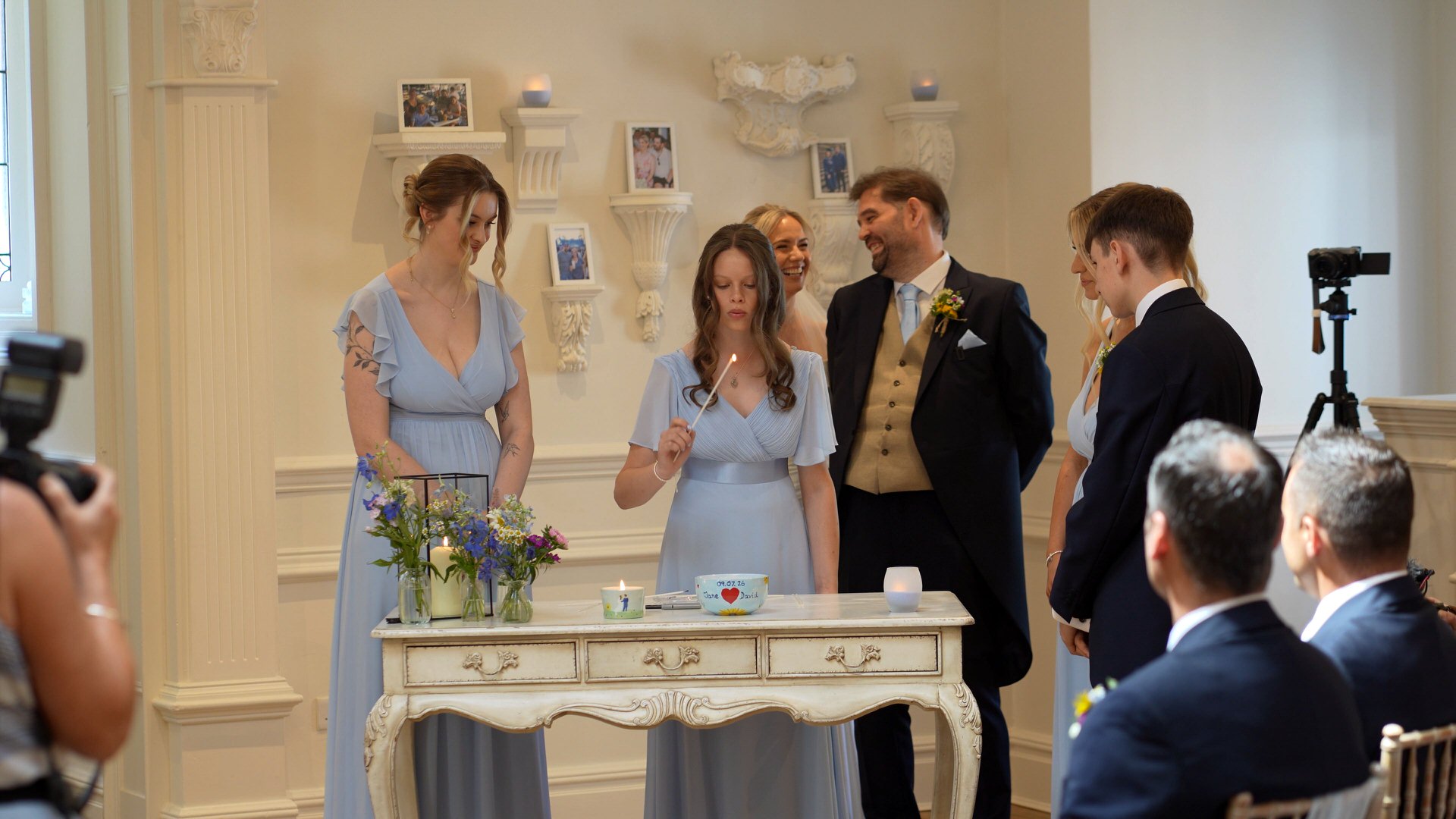 the family light a candle together during the wedding ceremony at Ashfield House