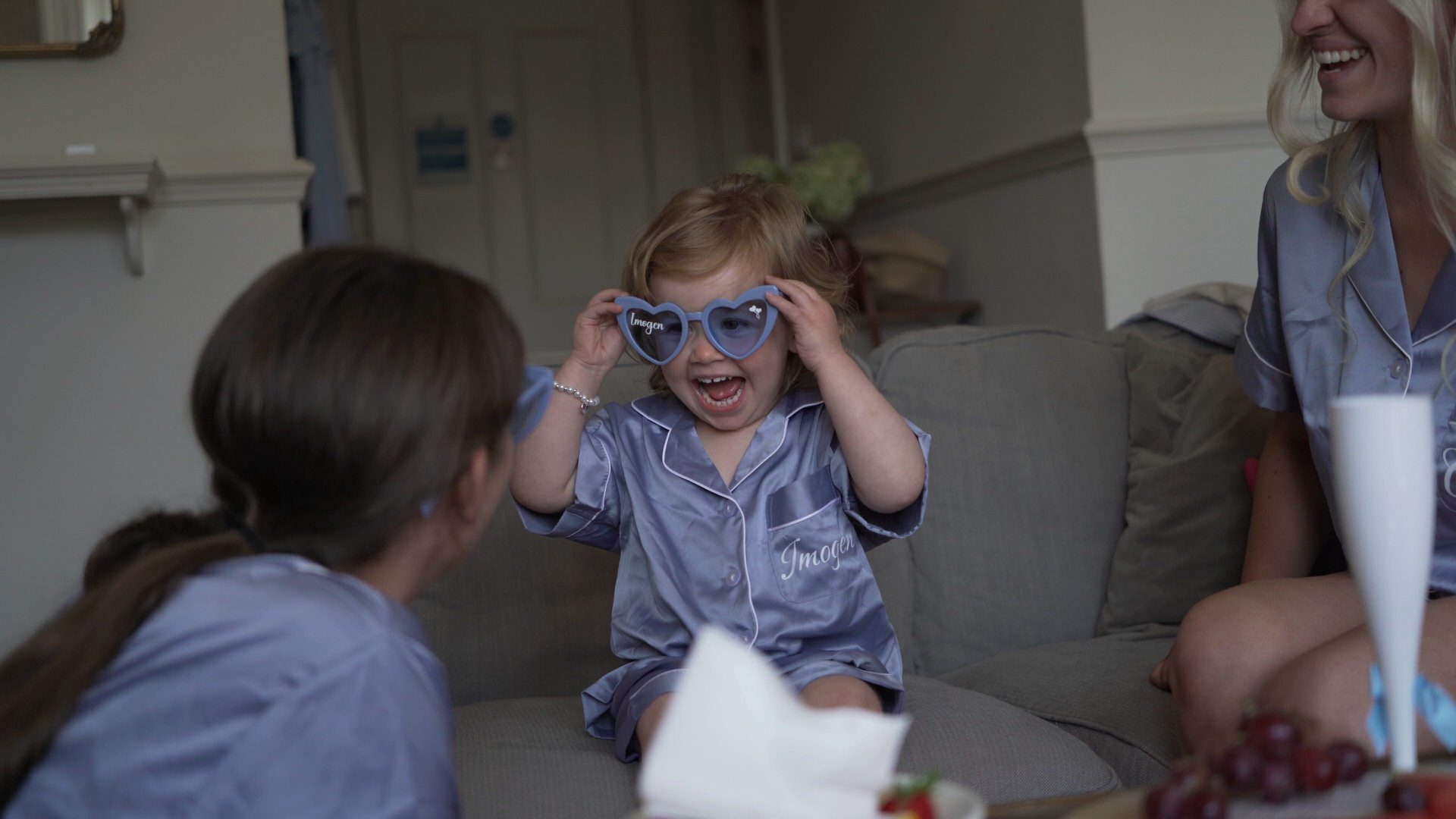 a fun video still of a flowergirl playing with custom wedding glasses