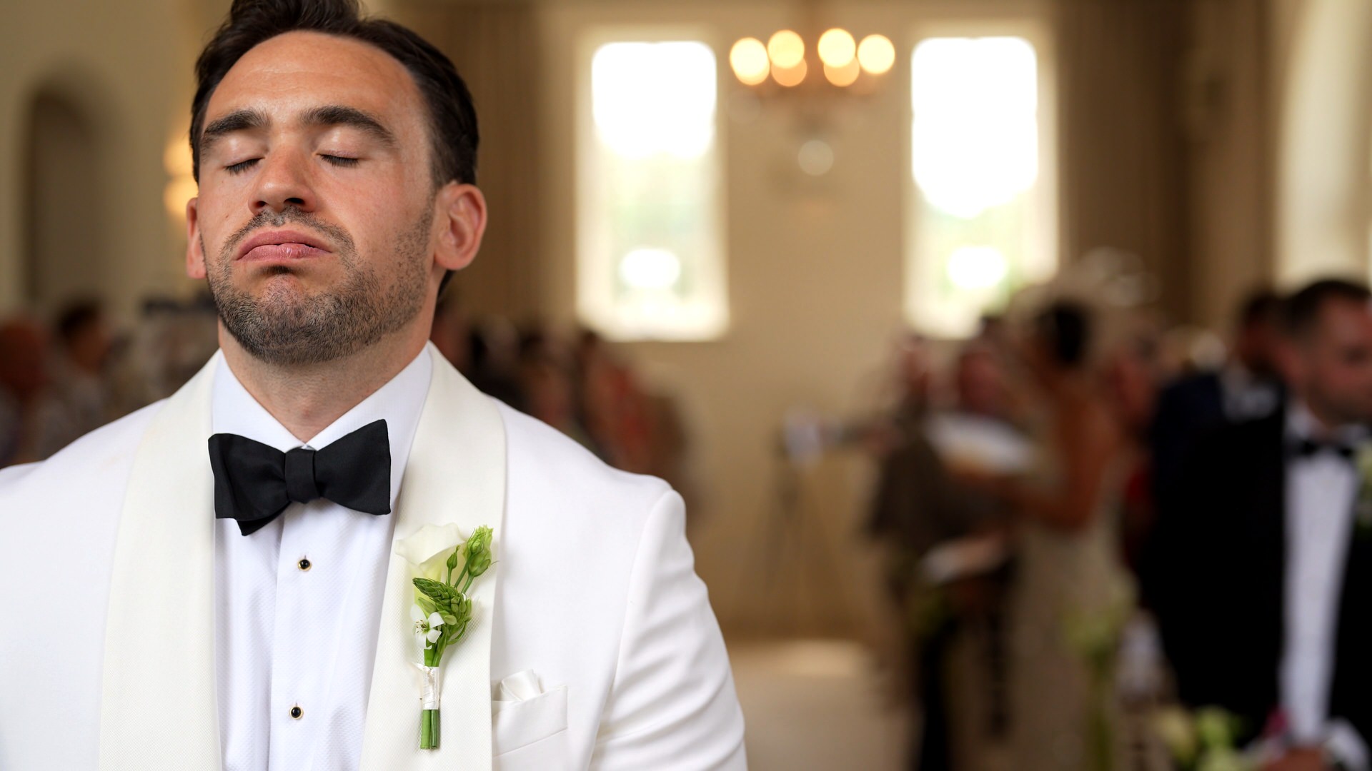 a groom in white dinner jacket and bow tie takes a deep breath before the wedding ceremony at at Iscoyd Park