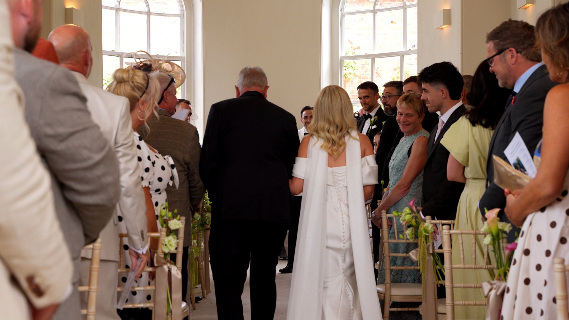 a second videographer captures the grooms reaction to the bride walking down the aisle at Iscoyd Park