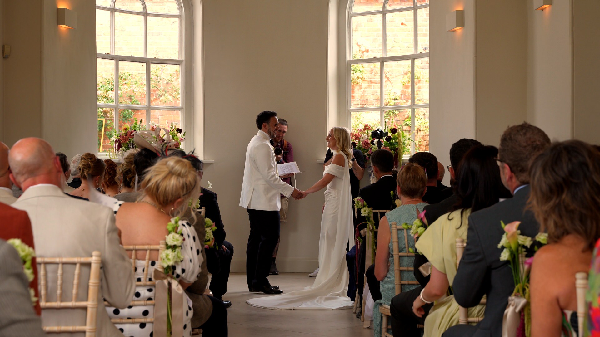 videographer films from the back of the garden room during a relaxed summer wedding ceremony at Iscoyd Park cheshire