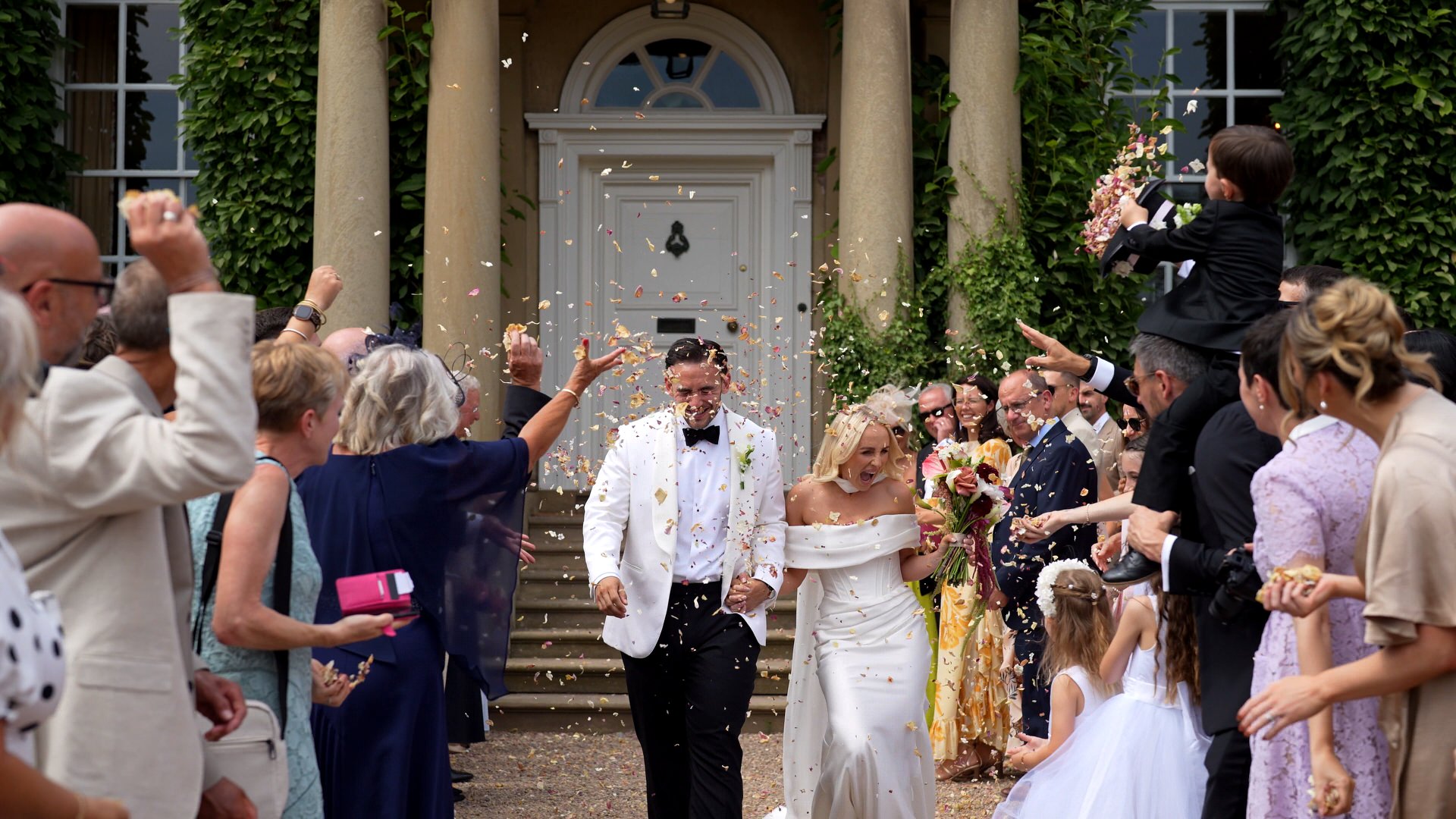 videographer captures the fun of a natural petal wedding confetti outside at Iscoyd Park