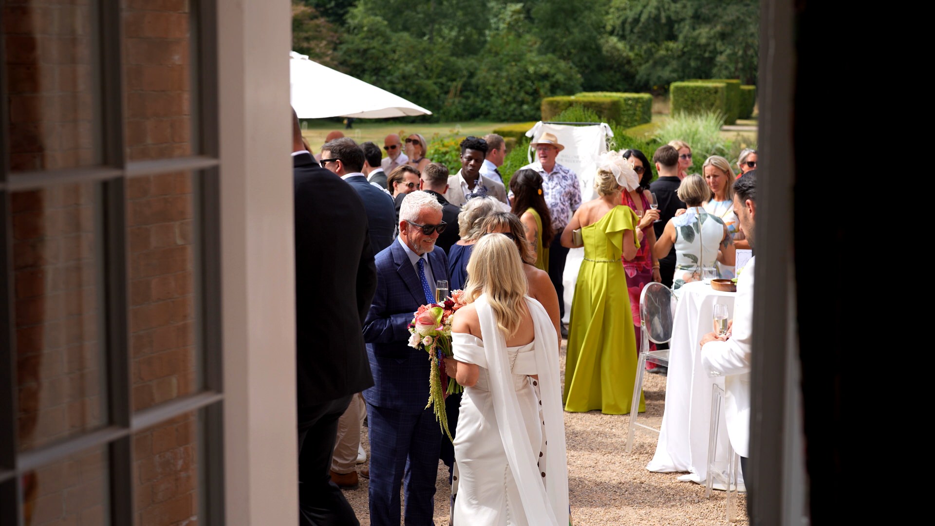 a discreet shot captured from inside Iscoyd showing guests mingling outside on the terrace for drinks