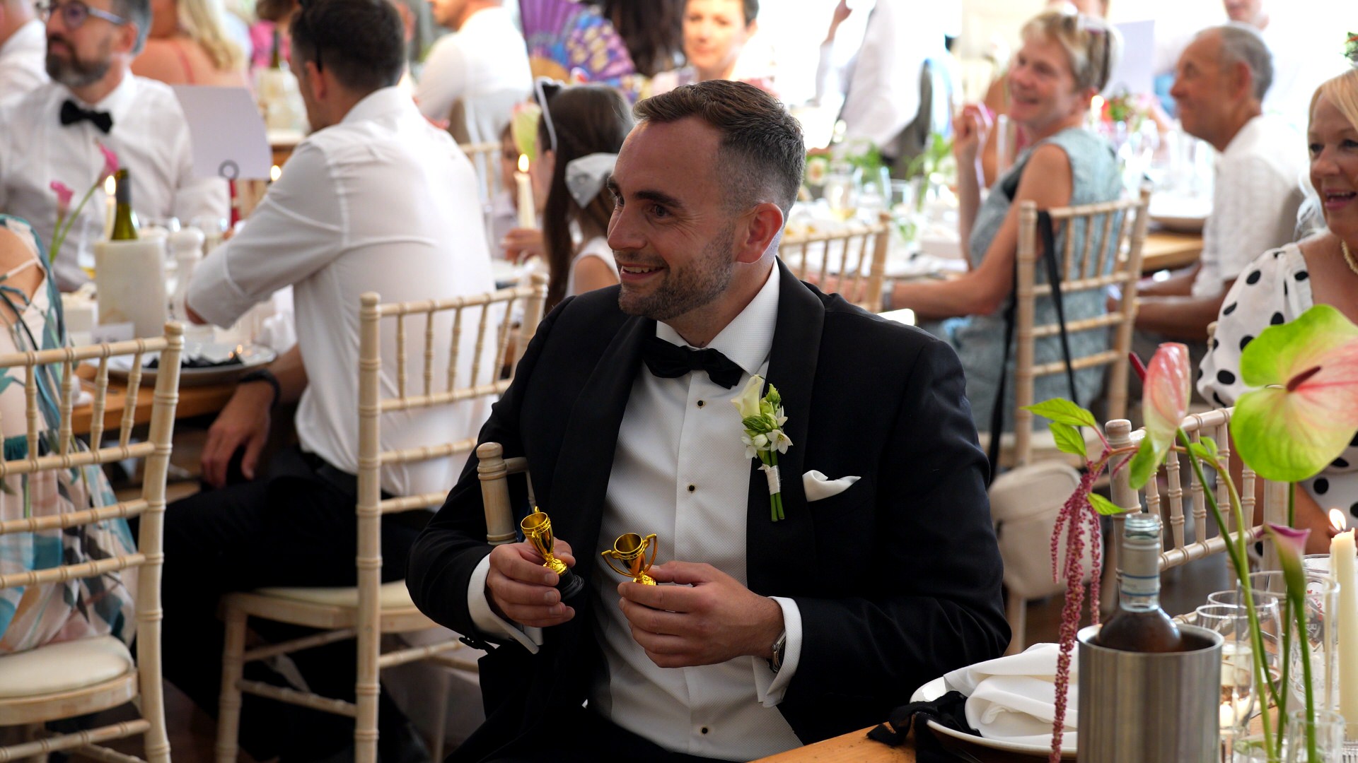 a guest holds his 'wedding awards' handed out by the couple during the wedding breakfast