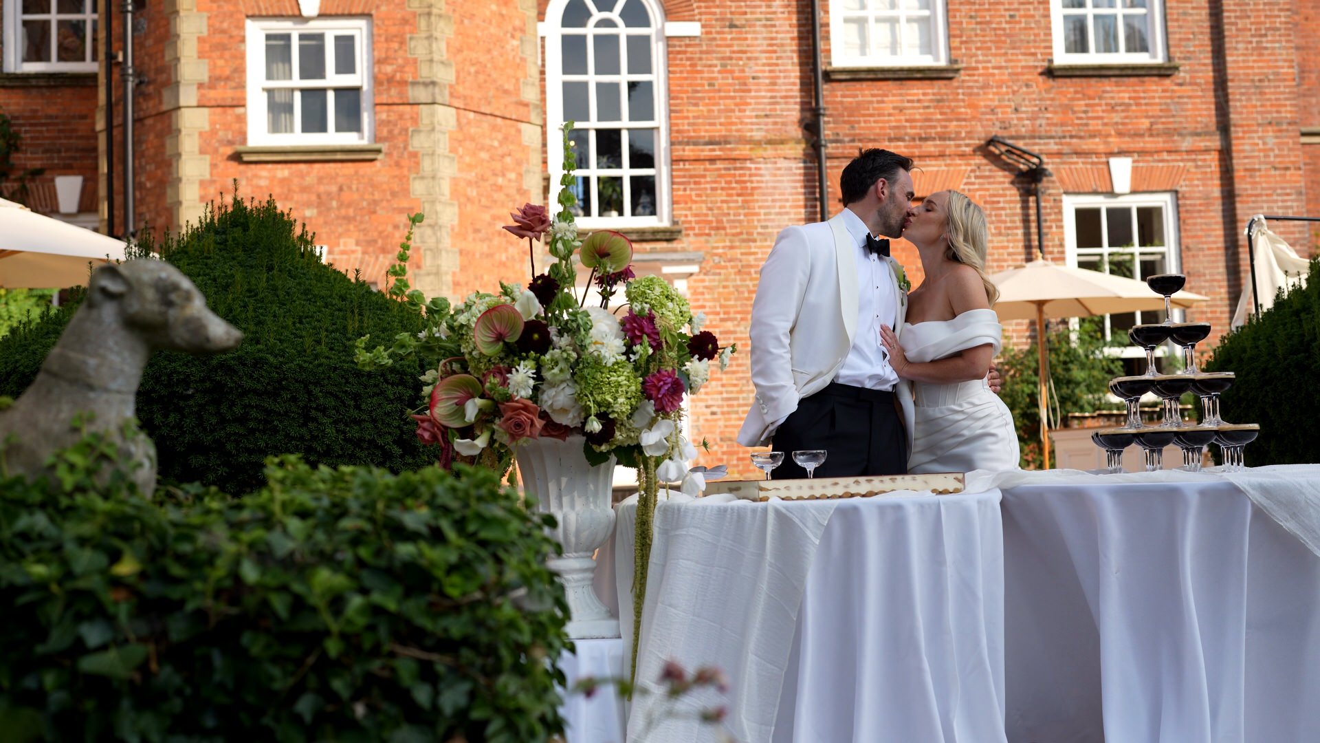 a couple kiss before they serve up their wedding tiramisu