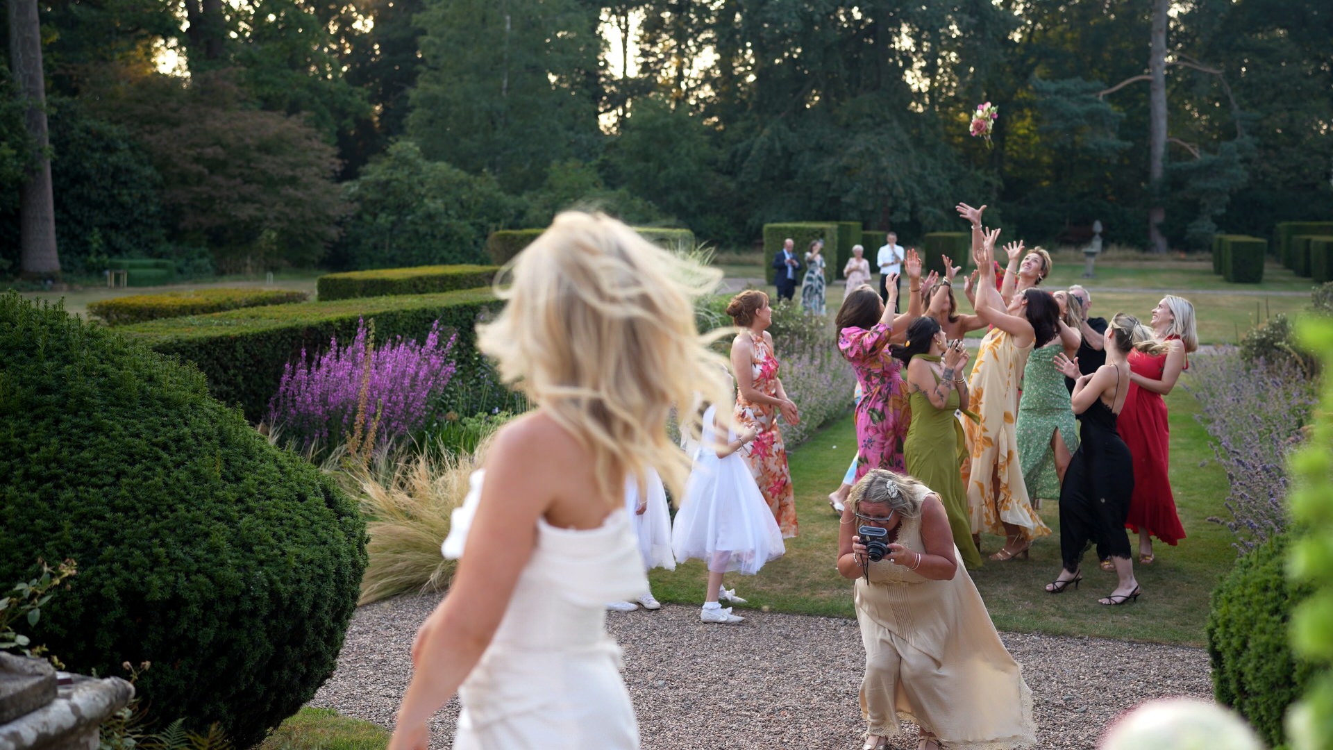 guests compete to catch the bouquet in the gardens at Iscoyd Park