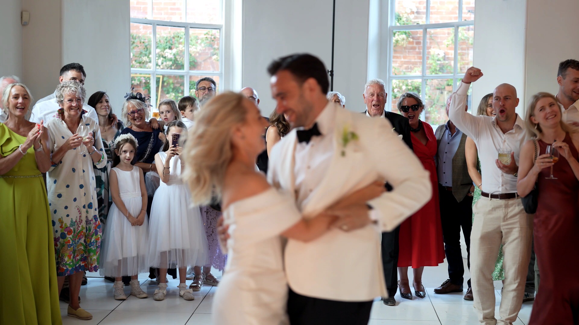 a unique shot of the guests singing and smiling as they watch the first dance at at Iscoyd Park