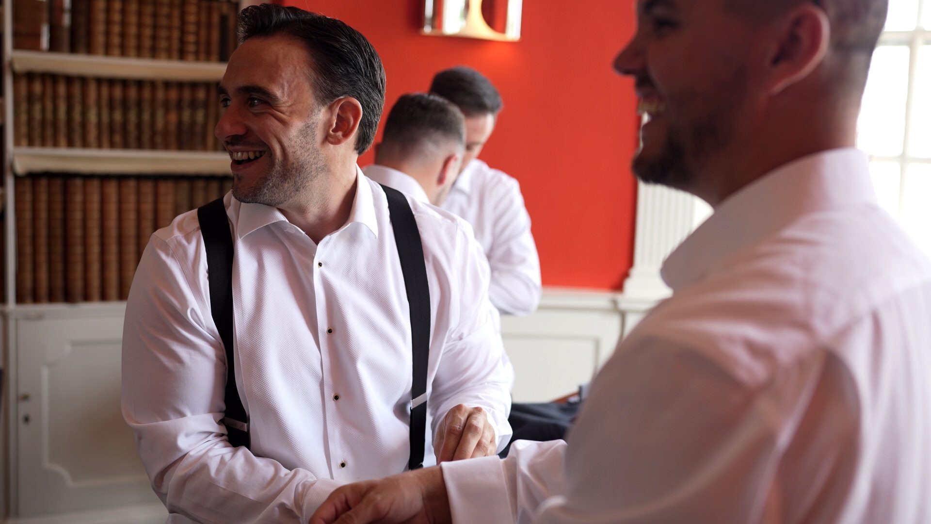 a groom getting ready for a summer black tie wedding laughs with his groomsmen at at Iscoyd Park