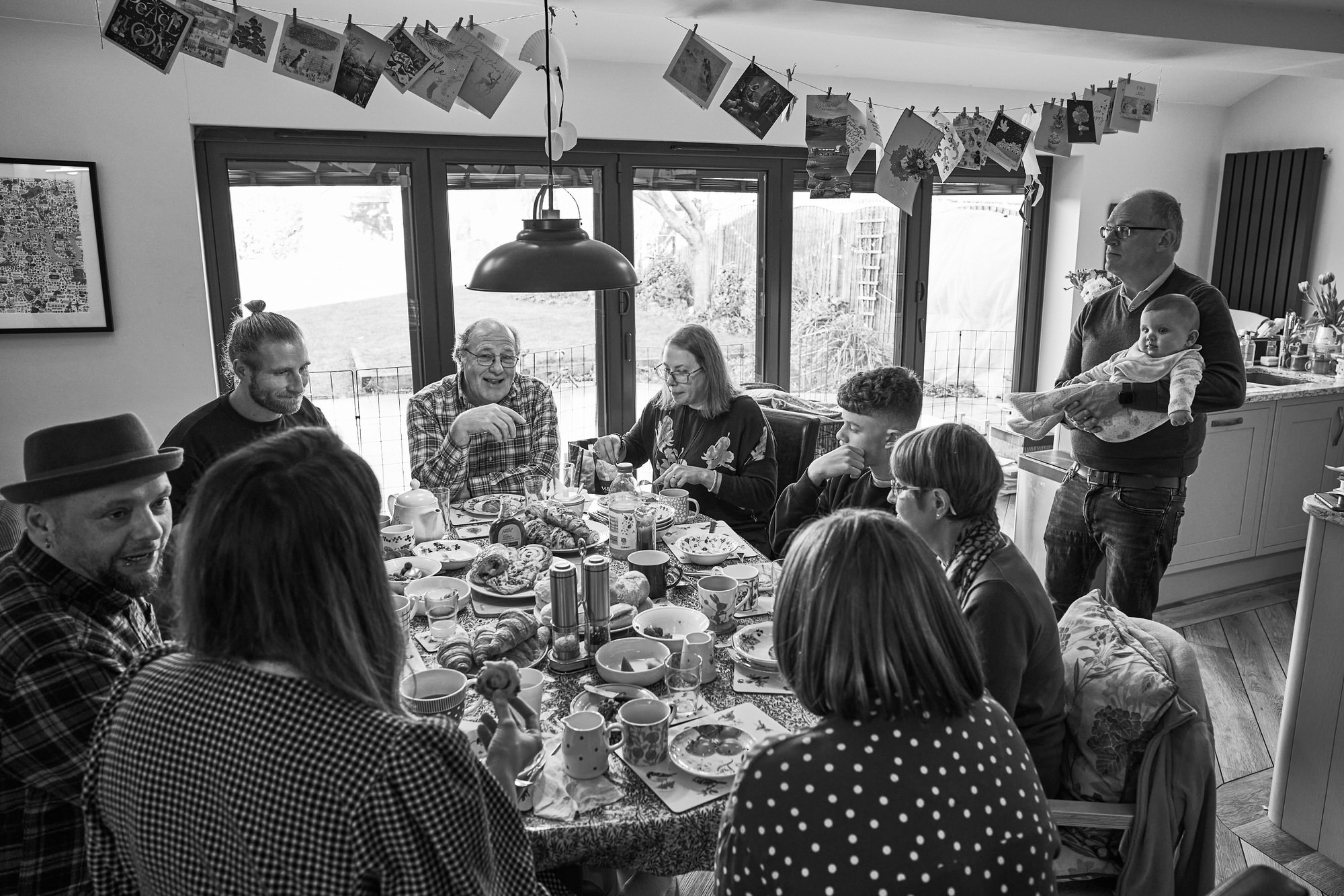 a wide shot of a large family gathering at home together for a photoshoot in Lancashire